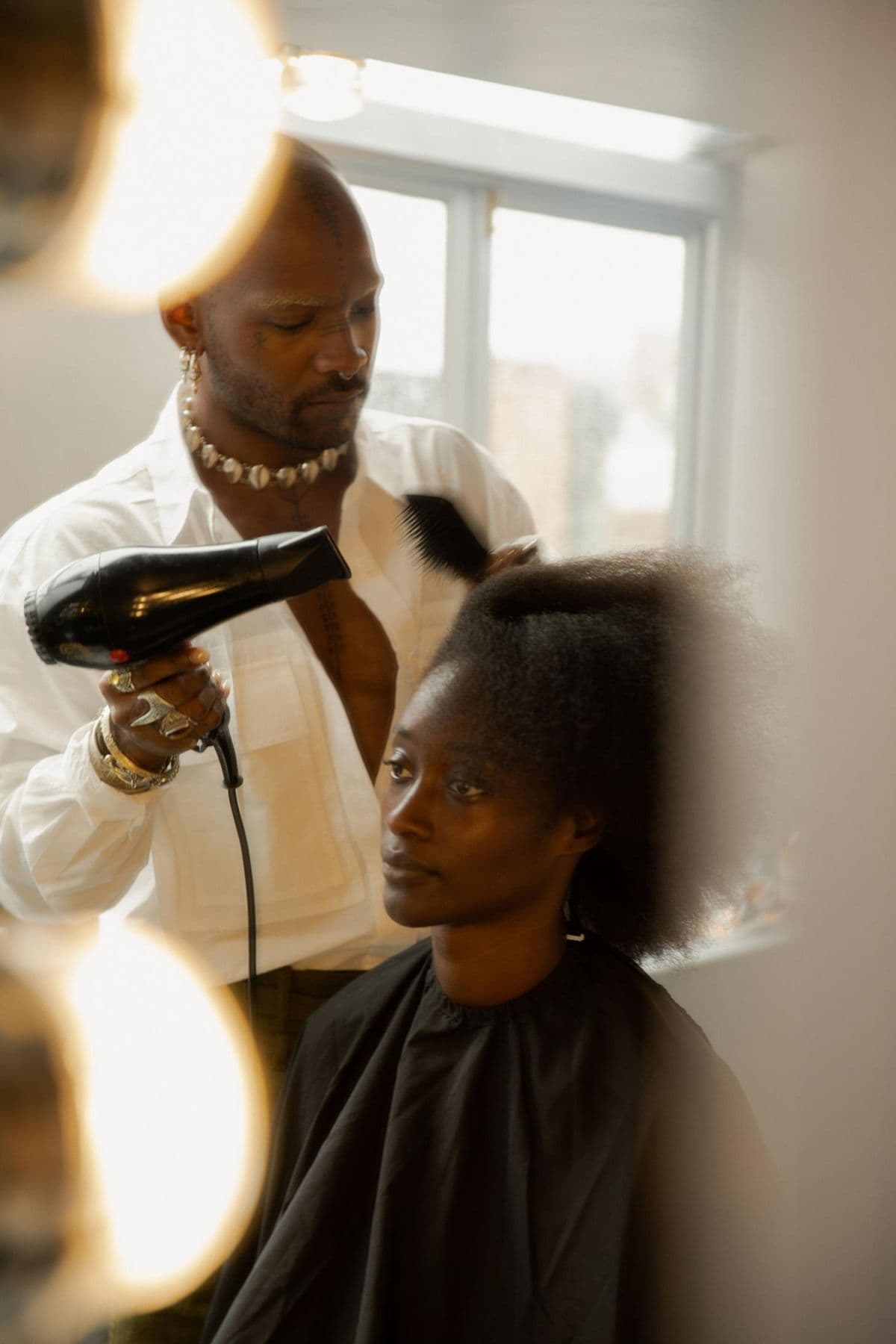 Stylist blow-drying a client's hair in the studio